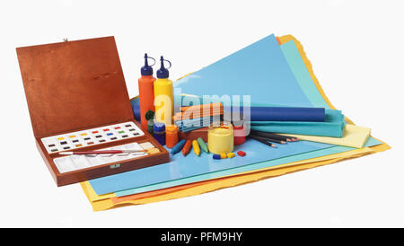 Selezione di materiali artistici, compreso il riquadro di acquerelli di blocchi, bottiglie di vernice, matite, pastelli pastelli colorati e la carta. Foto Stock