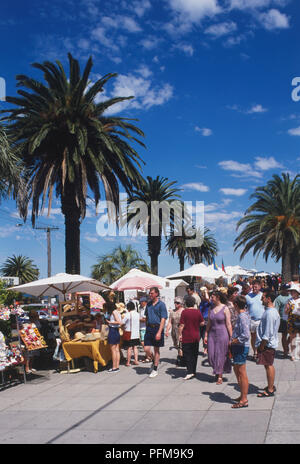 Australia, Melbourne, St Kilda Esplanade, folle in visita il mercato di artigianato su Palm tree- viale alberato. Foto Stock