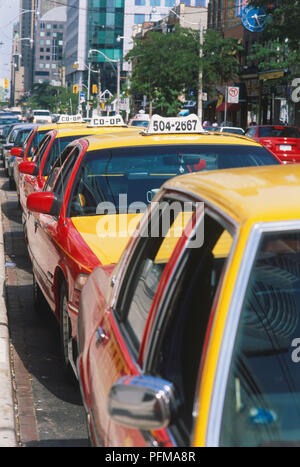 Canada Ontario, Toronto, rosso-giallo taxicabs schierate presso lo stand, vicino. Foto Stock