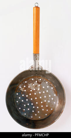 Chestnut tostatore, vaschetta di raccolta poco profonda con piccoli fori e manico in legno, utilizzato per la tostatura le castagne su fuoco di legna. Foto Stock