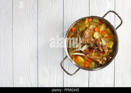 Islandese zuppa di agnello - kjotsupa in un acciaio inossidabile casseruola padella sulla tavola di legno, ricetta classica, vista da sopra Foto Stock