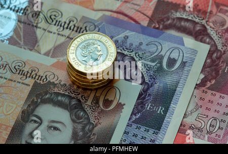 New British (GBP) pound monete in appoggio su £50, £20, £10 pound note. Foto Stock