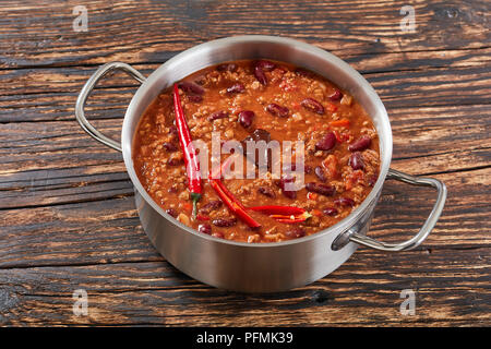 Una pentola di acqua calda deliziosa chili con carne con tutto il red hot chilis, fagioli, pomodori e pezzo di cioccolato, vista da sopra Foto Stock