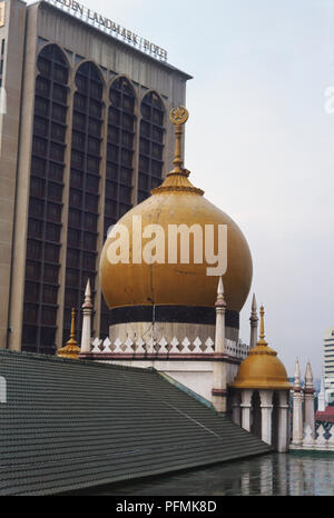Singapore, Kampong Glam, la Moschea del Sultano, due gold-cupole colorate con sottolineato di pinnacoli e simbolo islamico, Arabesque stylings con sfumature moresco, alto e moderno in background la creazione di un forte contrasto architettonico. Foto Stock