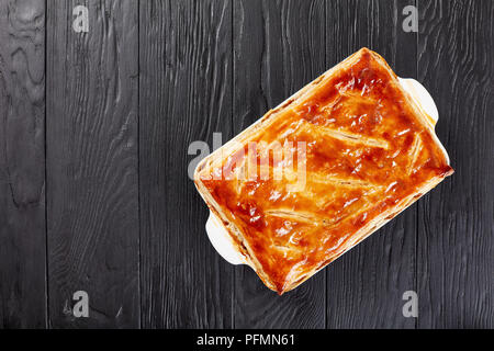 Deliziose Carni bovine e torta di Funghi Conditi con crosta dorata sfoglia di pasta sfoglia in una teglia su tavoli in legno nero, cucina australiana, vista da sopra Foto Stock