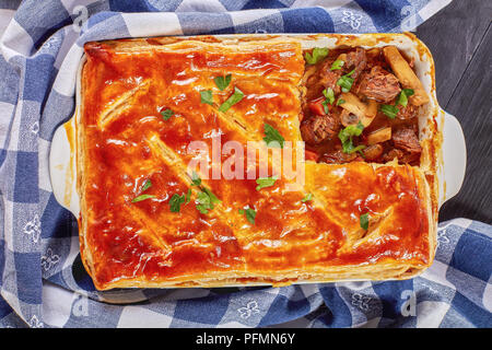 Appena sfornato carne australiana e torta di Funghi Conditi con crosta dorata sfoglia di pasta sfoglia in una teglia sul tavolo di legno con carta asciugatutto, vista fr Foto Stock