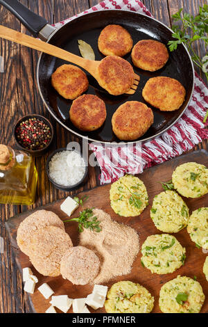 Croccante di riso cotolette o chawal ki tikki su una padella sul tavolo di legno con costolette crudo, paneer cubetti di formaggio e pane grattugiato sul tagliere, India Foto Stock