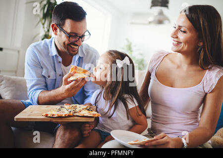 Felice Condivisione in famiglia pizza insieme a casa Foto Stock