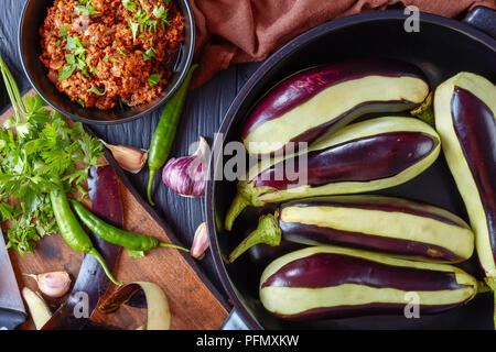 Ingredienti per la cottura di melanzane ripiene, melanzane - ragù di carne di manzo macinata carni, pomodori e cipolle e fresche le melanzane in una teglia e su Foto Stock