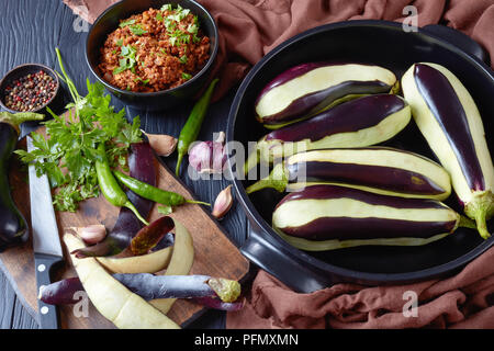 Ingredienti per la cottura di melanzane ripiene, melanzane - ragù di carne di manzo macinata carni, pomodori e cipolle e fresche le melanzane in una teglia e su Foto Stock