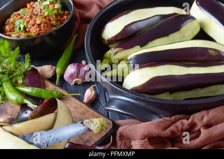 Ingredienti per la cottura di melanzane ripiene, melanzane - ragù di carne di manzo macinata carni, pomodori e cipolle e fresche le melanzane in una teglia e su Foto Stock