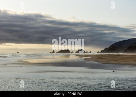 Cannon Beach su una sera Nuvoloso con pile di mare e Ecola State Park in distanza, US Route 101, Oregon Coast, Stati Uniti d'America. Foto Stock