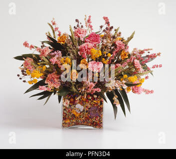 Profumi di fiori secchi contenuti in forma rettangolare vaso di vetro con pot-pourri in base del vaso. Foto Stock