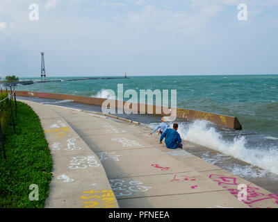 Chicago, Illinois, Stati Uniti d'America. Il 21 agosto 2018. Un paio di wave watchers dodge una sosta a Montrose punto. Rigido venti di nord-est mantecato fino surf sul lago Michigan, portando fuori kayakers, kite surfers e wave watchers. Credito: Todd Bannor/Alamy Live News Foto Stock