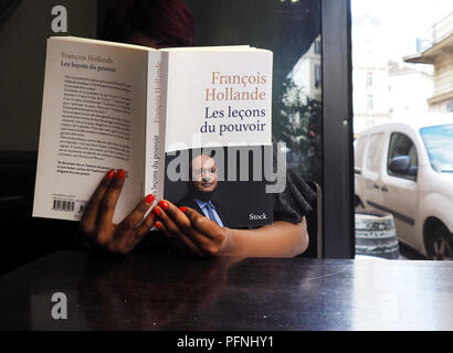 Parigi, Francia. Il 22 agosto, 2018. Una donna che legge il memorial libro 'Les leçons du pouvoir' dall ex Presidente francese François Hollande in un caffè di Parigi. Credito: Christian Böhmer/dpa/Alamy Live News Foto Stock