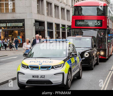 Londra, Regno Unito. Il 22 agosto, 2018. Parte dello sforzo per ripulire l'aria in Oxford Street include l'introduzione di veicoli elettrici o ibridi - in questo caso una BMW elettrico auto della polizia, in uno dei nuovi electric London Black Cabs ed un ibrido double decker bus di Londra Londra 22 ago 2018. Credito: Guy Bell/Alamy Live News Foto Stock