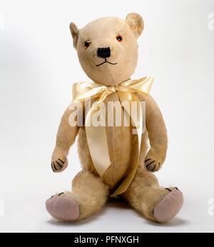 Orsacchiotto di peluche con nastro giallo bow legato attorno al collo Foto Stock