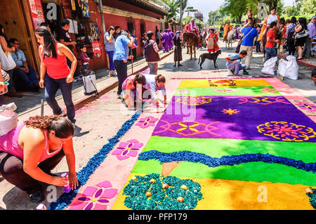 Antigua Guatemala - Aprile 2, 2015: rendendo segatura colorata processione tappeto nel Patrimonio mondiale dell UNESCO con il famoso alle celebrazioni della Settimana Santa. Foto Stock