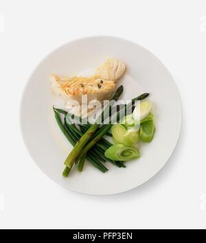 Piccole porzioni di grigliate di pesce bianco e cotto a vapore le punte di asparagi, fagioli verdi e il trito di perdite, servita su una piastra Foto Stock