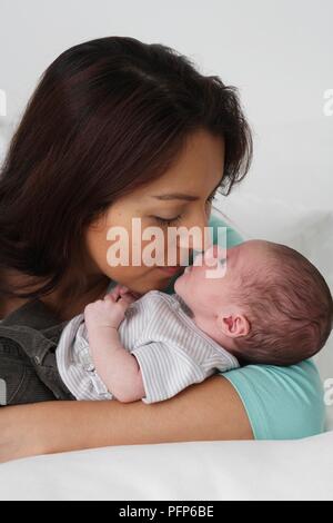 Donna che mantiene baby boy nel suo braccio strofinando il naso contro il suo, close-up Foto Stock