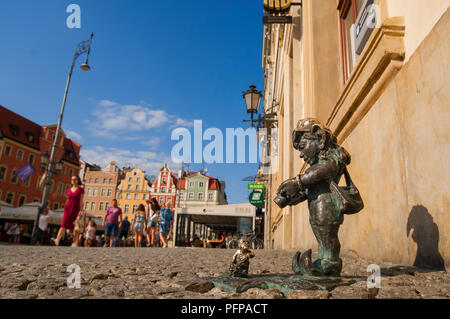 Wroclaw, Polonia, agosto 2018. Wroclaw nana, 'gnome' fotograf (fotografo) prendendo foto di nana più piccoli con Wroclaw piazza principale in background. Foto Stock