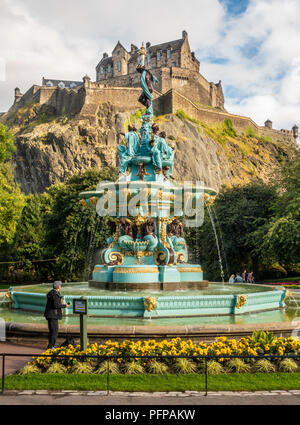 Un turista con una telecamera si ammira il rinnovato Ross fontana nella zona ovest di Princes Street Gardens, di fronte al Castello di Edimburgo. La Scozia. Foto Stock