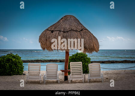 Palapa e sedie a sdraio sulla spiaggia nella baia di Fatima, Puerto Aventuras, Quintanna Roo Mexico. Foto Stock