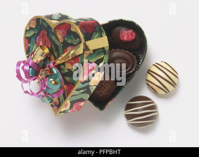 Decorate a forma di cuore scatola di cioccolatini, parzialmente aperta, vista da sopra Foto Stock