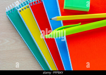 Si torna a scuola concetto, forniture scolastiche, vista dall'alto di colorate notebook e matite Foto Stock