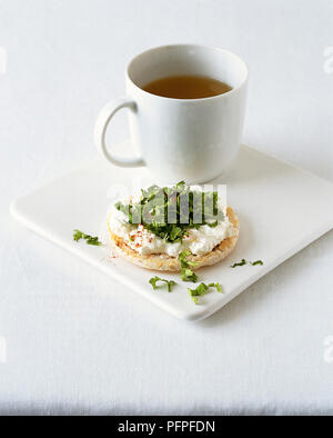 La tazza di minestra chiaro servito con riso cake, conditi con formaggio e un trito di coriandolo fresco Foto Stock