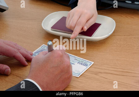 L'uomo la firma di verifica al punto indicato da donna Foto Stock