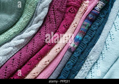 Cime di maglia di diversi colori e maglie in una pila Foto Stock