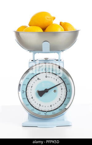 Ciotola di limoni sulla bilancia da cucina Foto Stock