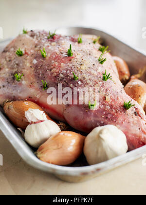 La gamba di agnello costellata di rosmarino, in teglia, close-up Foto Stock