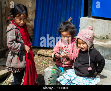 GHALEGAUN, NEPAL - CIRCA NEL MAGGIO 2018: tre giovani ragazze nepalese giocando al di fuori della loro casa. Foto Stock