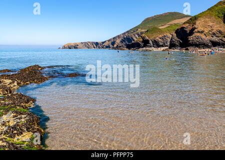 Pendinas Lochtyn visto attraverso la baia dalla spiaggia Llangrannog, Ceredigion, Galles Foto Stock