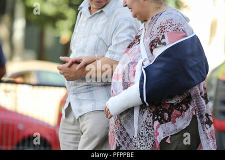 Bucarest, Romania - 13 agosto 2018: coppia di anziani a piedi da Floreasca emergenza ospedale, dove la signora aveva il suo braccio sinistro messo in un calco in gesso Foto Stock