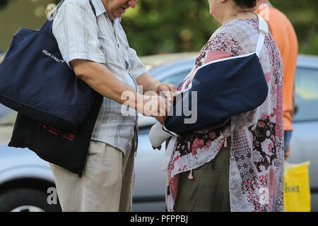 Bucarest, Romania - 13 agosto 2018: coppia di anziani a piedi da Floreasca emergenza ospedale, dove la signora aveva il suo braccio sinistro messo in un calco in gesso Foto Stock