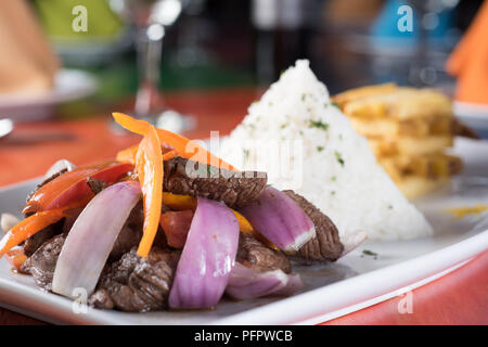 La cucina peruviana lomo saltado :una carne salata con pomodoro, cipolla e patate fritte e riso. Foto Stock