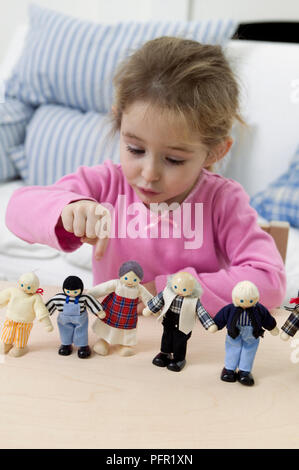 Ragazza puntando alla bambola in fila, close-up Foto Stock