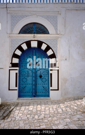 La Tunisia, Sidi Bou Said, blu porta sulla strada di ciottoli, costellato di ornamentazione Foto Stock