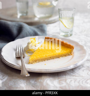 Tarte Au Citron, Francese crostata al limone con la panna e la scorza di limone, su di una piastra con forca Foto Stock