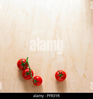 Pomodori a grappolo su sfondo di legno Foto Stock