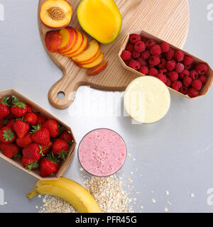 Ingredienti Smoothie, fragole, lamponi e pesche tagliate a fette, mango e banana Foto Stock