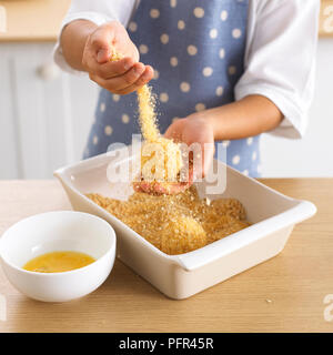 Ragazzo breadcrumbing per palle di riso Foto Stock