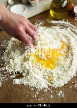 La miscelazione di uovo, olio di oliva e la farina (rendendo la pasta) Foto Stock