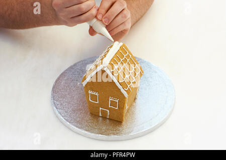 Piping ciliegina sulla casa di panpepato Foto Stock