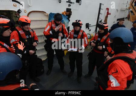 Un USCGC Mellon (WHEC 717) Imbarco team conduce una breve di sicurezza prima di salire a bordo di un peschereccio durante un Alaskan patrol a sostegno della vita resoures marino missione nel mare di Bering, Alaska, 22 maggio 2018. Il Mellon equipaggio applicate le leggi e i regolamenti relativi alla conservazione della pesca degli Stati Uniti stock. Stati Uniti Coast Guard Foto Stock