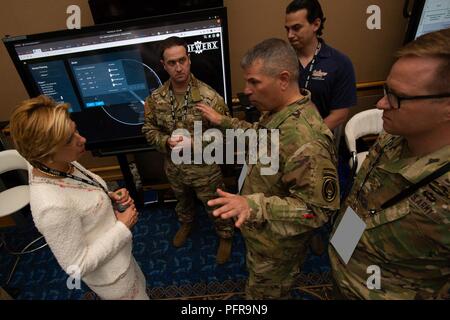 I membri di Stati Uniti Il Comando Operazioni Speciali J4 direzione breve gli onorevoli Ellen M. Signore, sotto il segretario della difesa per acquisizione e supporto, come parte di una vetrina dell'innovazione durante il 2018 forze per le operazioni speciali conferenza di settore in downtown Tampa, Florida, 23 maggio 2018. Le forze per le operazioni speciali Industry Conference è la prima conferenza per la comunità SOF per interagire con i fornitori e a collaborare per offrire alla nuova tecnologia warfighters. Foto Stock