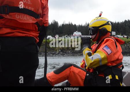 Coast Guard marinaio apprendista Nicholas Barnes si prepara a uscire dalla 38-piede ausili alla navigazione in barca di risposta a piccole come parte di una ricerca e dimostrazione di salvataggio per il Kodiak Crab Festival a San Paolo Porto di Kodiak, Alaska, 26 maggio 2018. Barnes simulato il ruolo del superstite in acqua in attesa di Coast Guard assistenza. Stati Uniti Coast Guard Foto Stock